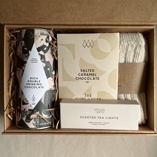 Luxury gift box containing rich double drinking chocolate, salted caramel chocolate bar, a pack of scented tea lights and a pair of alpaca socks.