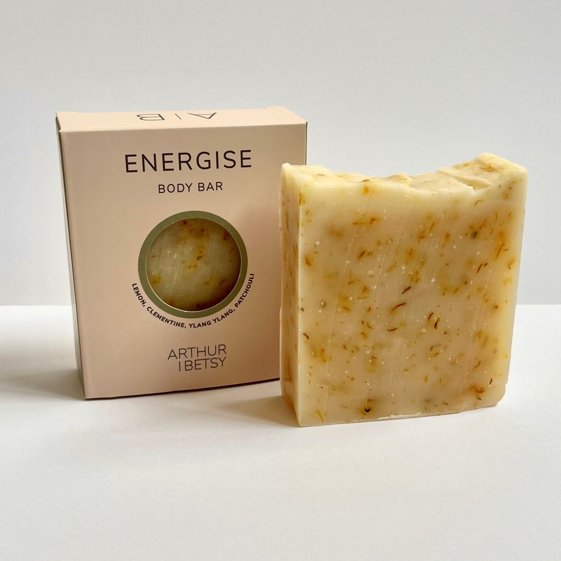 Beige colored aromatherapy luxury soap bar next to its packaging box, labeled ENERGISE.