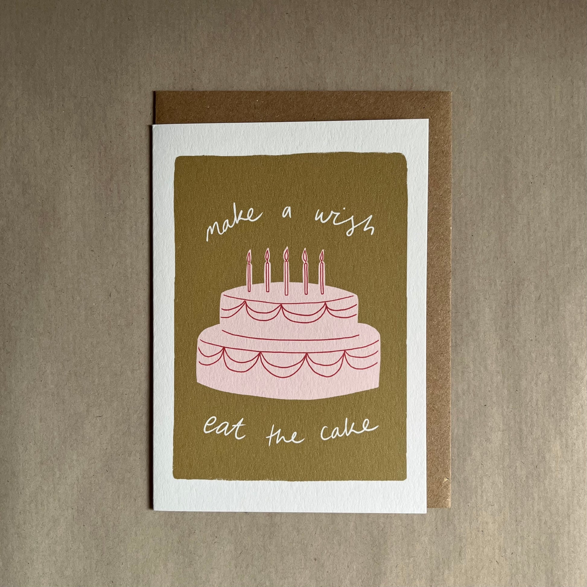 Greeting card with a cake illustration and text saying make a wish, eat the cake.  Perfect happy birthday cake card.