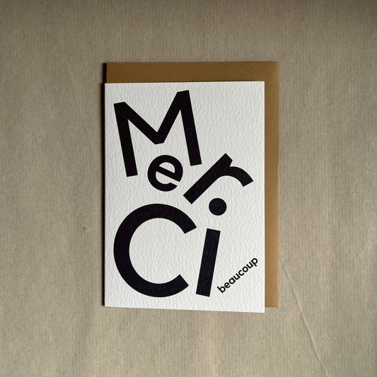 Thank you greeting card with 'Merci beaucoup' text on a beige background