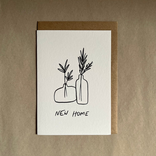 New home greeting card with illustrations of vases and plants on a beige background with the text ‘new home’ underneath