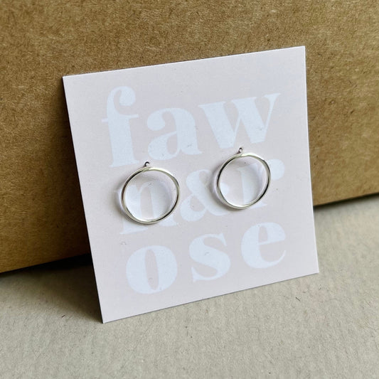 Close up of silver circle earrings on blush pink card propped up against a Kraft gift box