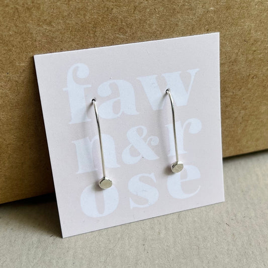 Close up image of silver ear thread earrings on blush pink card with words fawn and rose on.  Shown propped up against a Kraft gift box.
